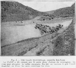 Fig. 2. - UNE VALL�E TRANSVERSALE, ORIENT�E SUD-NORD Le Ch�liff a d� creuser son lit entre deux cha�nes de montagnes; les rives sont abruptes la vall�e encaiss�e. En �t�, on traverse � gu� l'oued dess�ch�: en hiver, les eaux couvriront les rives.